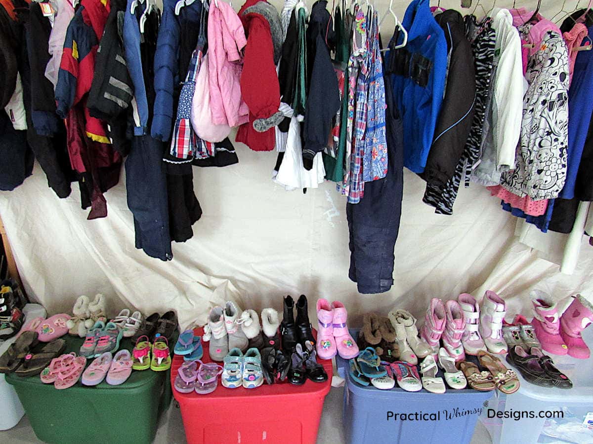 Hanging clothes and shoes for sale at a garage sale