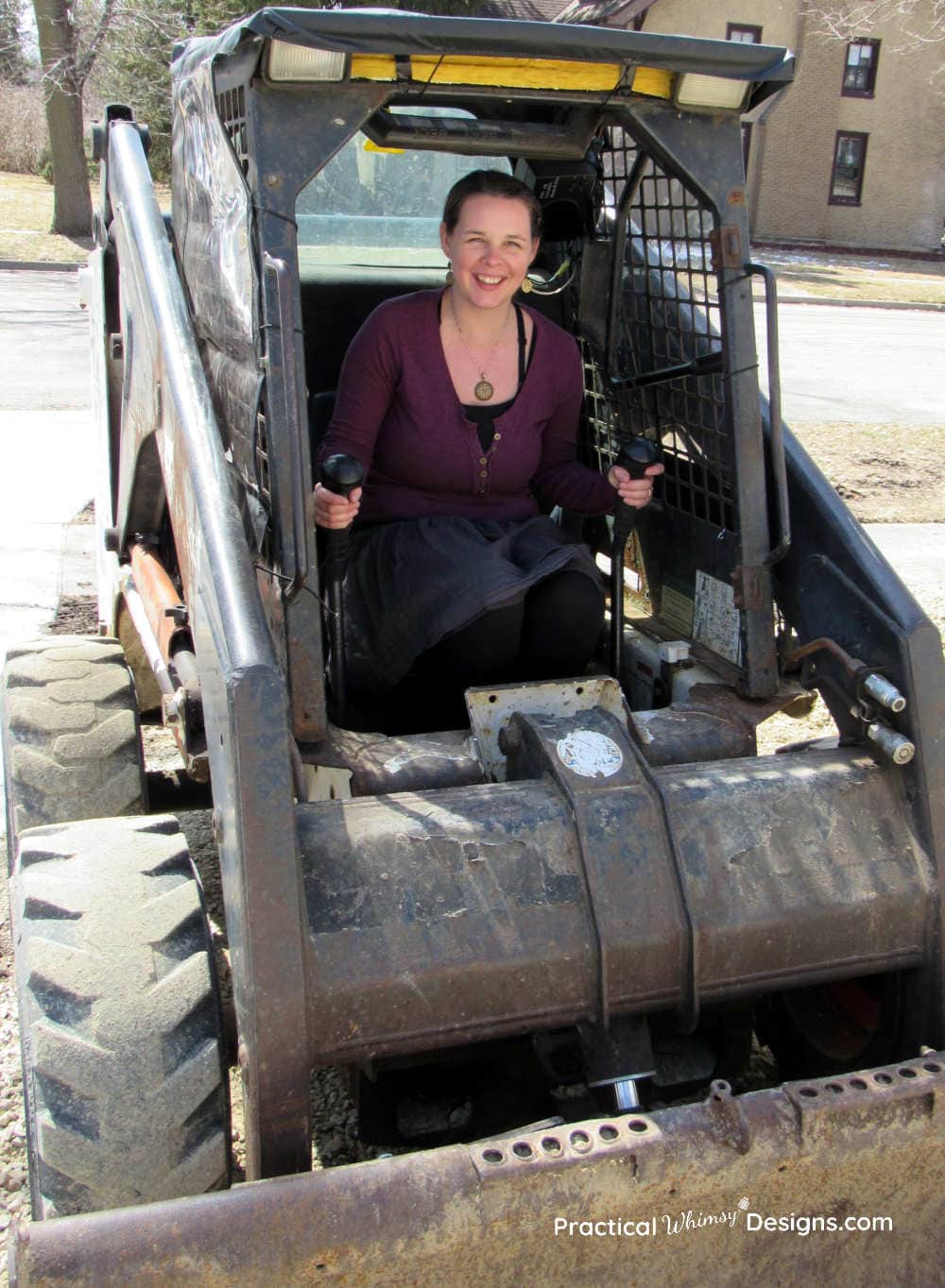 Lady sitting in a bobcat smiling