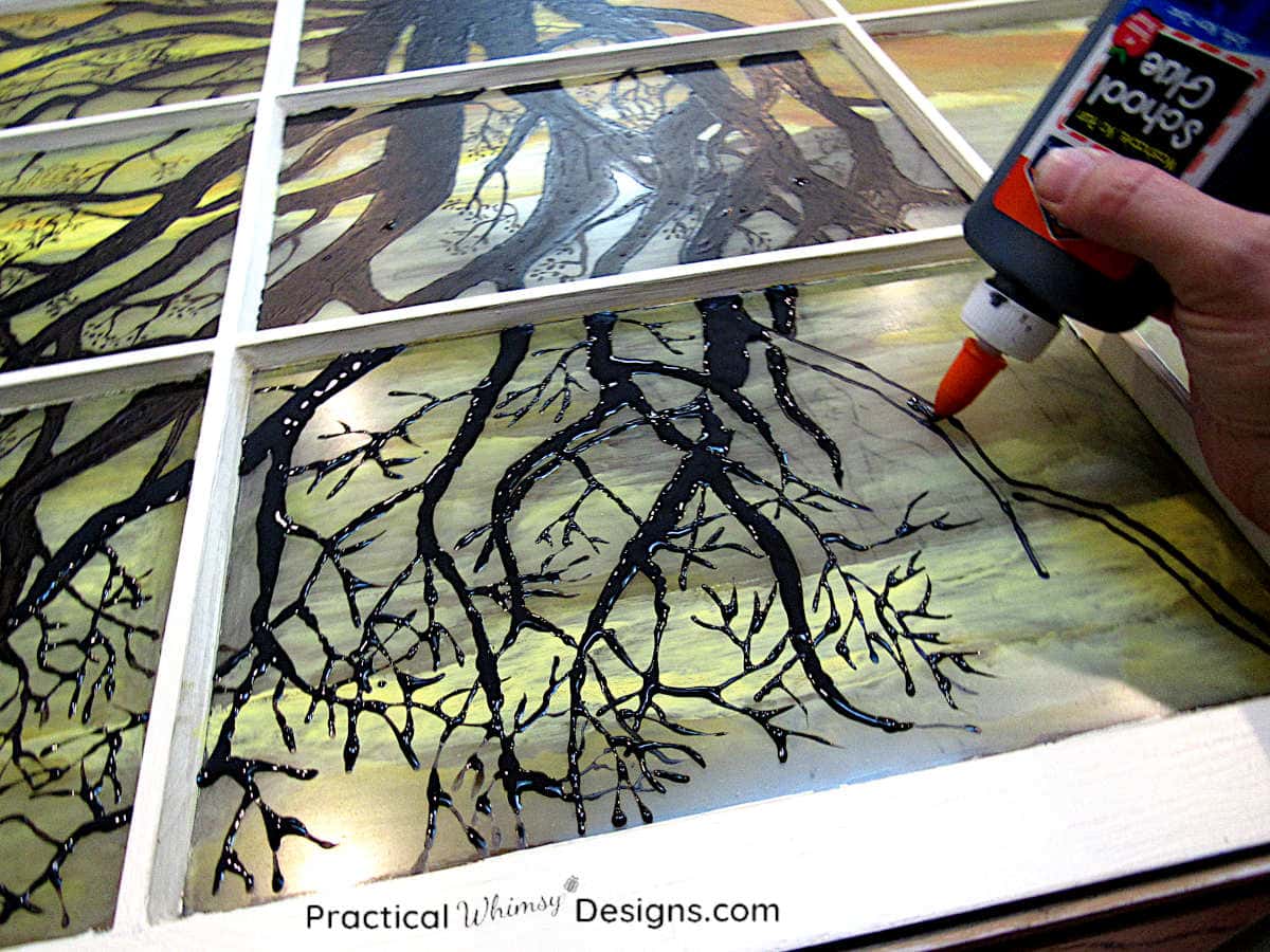 School glue and black paint used to make a DIY faux stained glass window silhouette tree.
