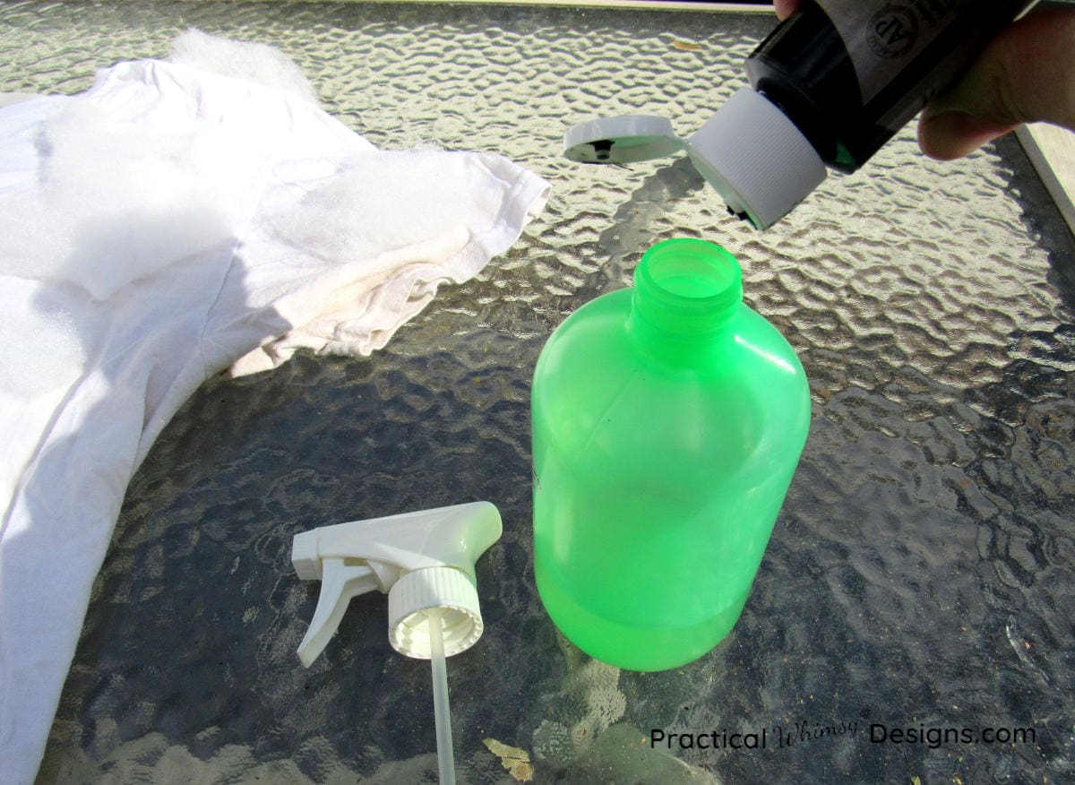 Mixing black paint and water in a spray bottle