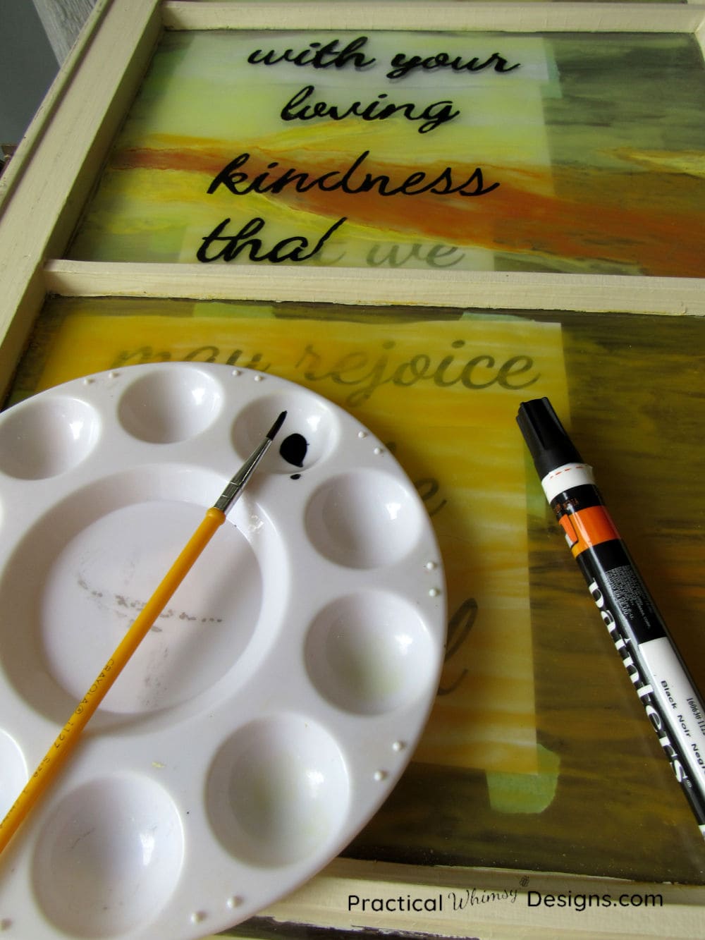 Painting words on glass with black paint marker.