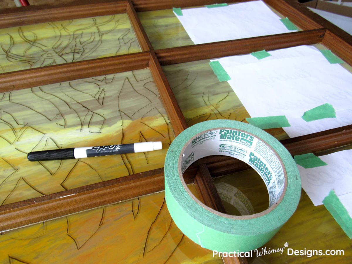 Outline of tree silhouette on glass window with paper taped on back with painter's tape.