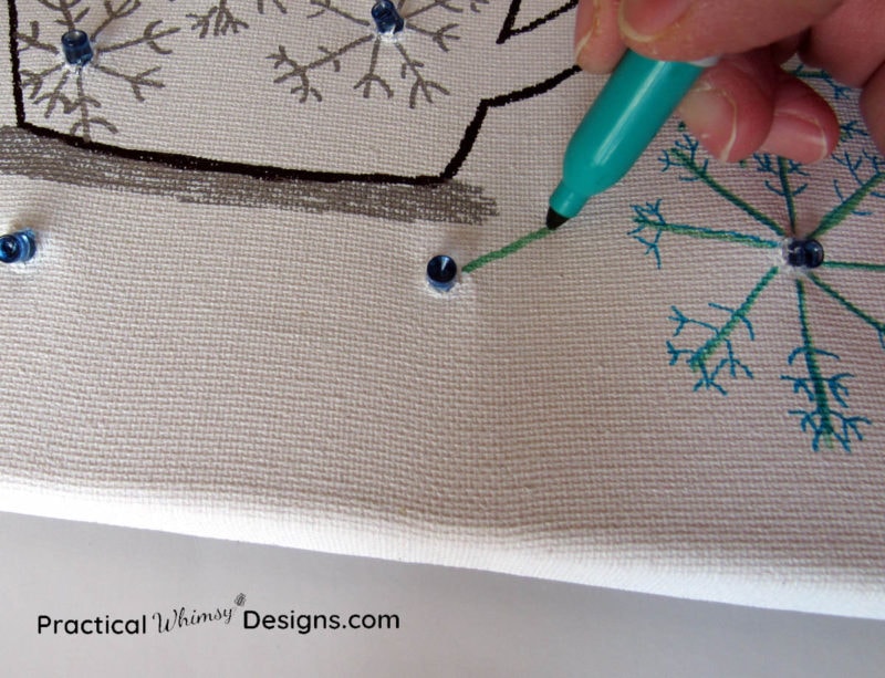 Drawing snowflakes on lighted canvas with a blue permanent marker