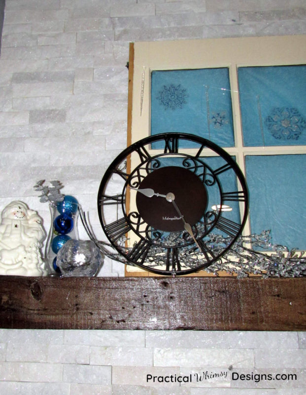 Icicle garland, snowflake decals, snowman, and clock on mantel