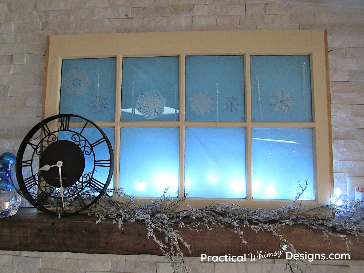 Clock, and window on mantel with snowflakes and blue lights
