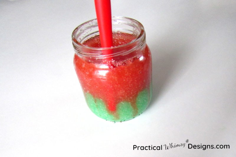 Pushing sugar down in jar with paint brush