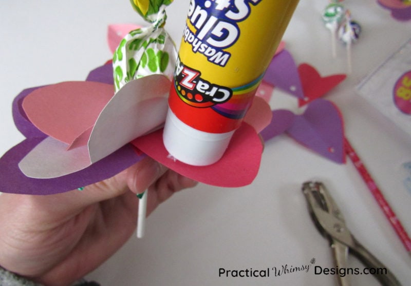 Gluing hearts on valentines card flowers