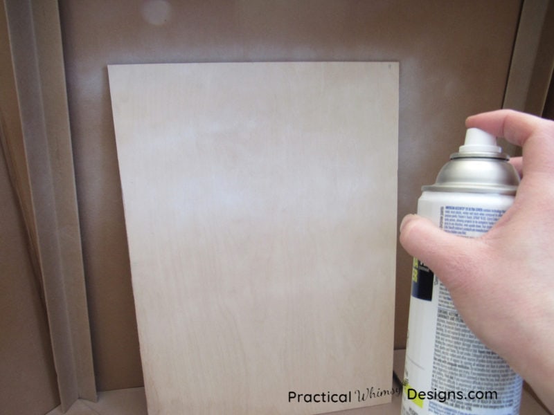 Spraying primer on a piece of plywood