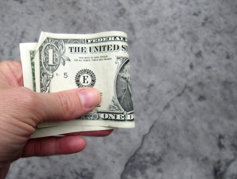 Dollar bill held in hand