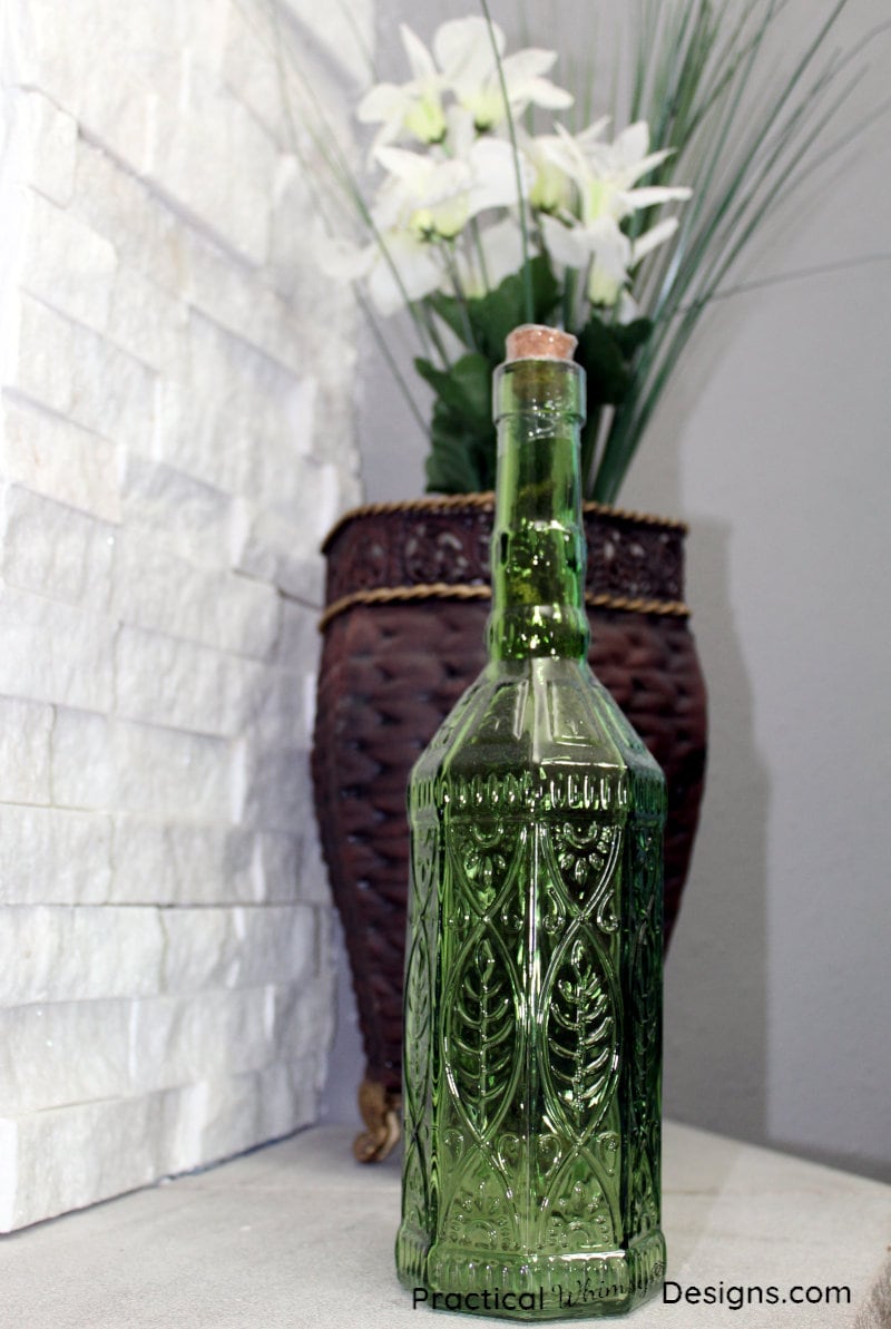 Green bottle by brown vase