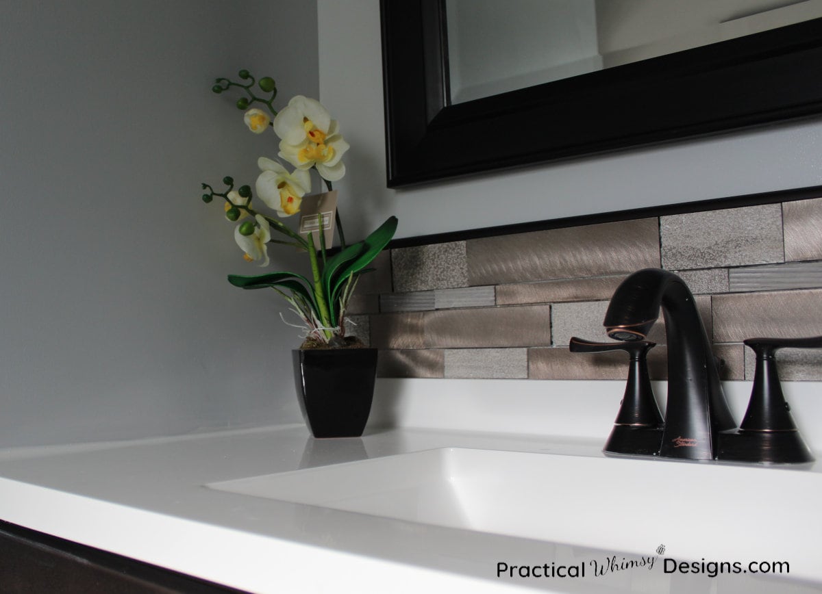 Sink and faucet with white orchid sitting on it