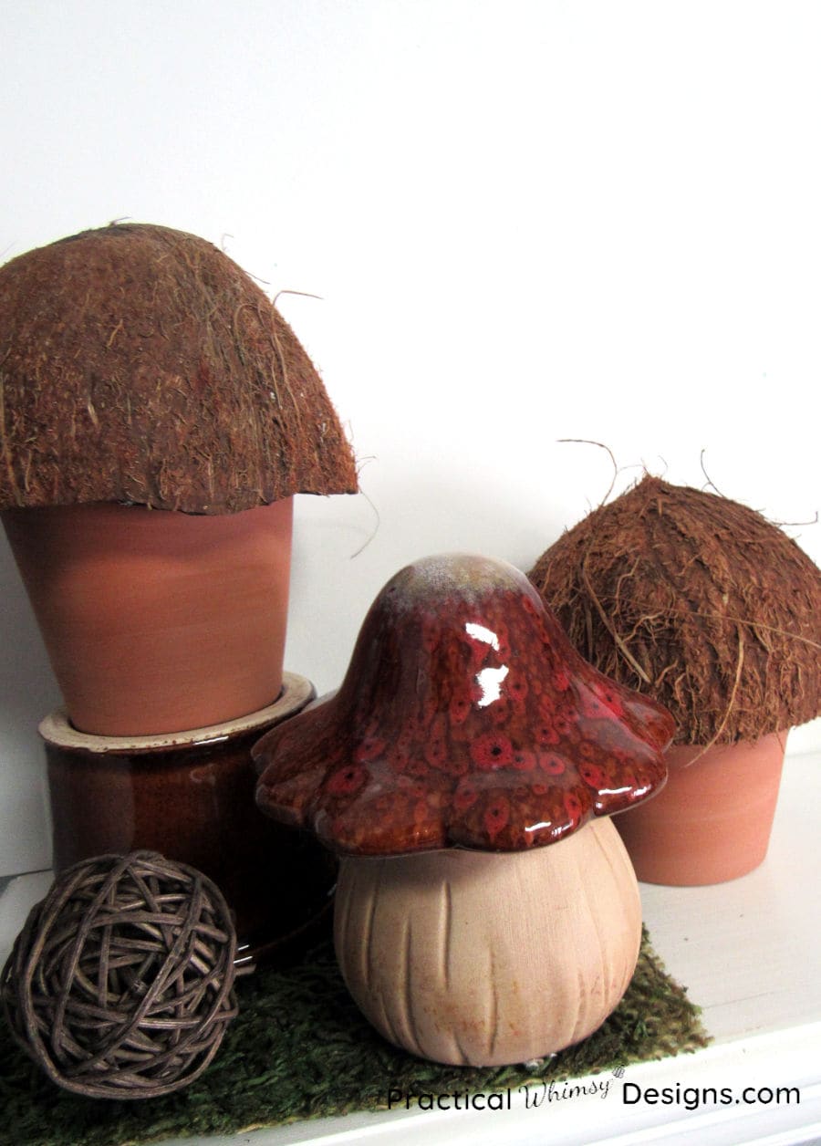 Three mushroom decorations sitting on a white shelf.