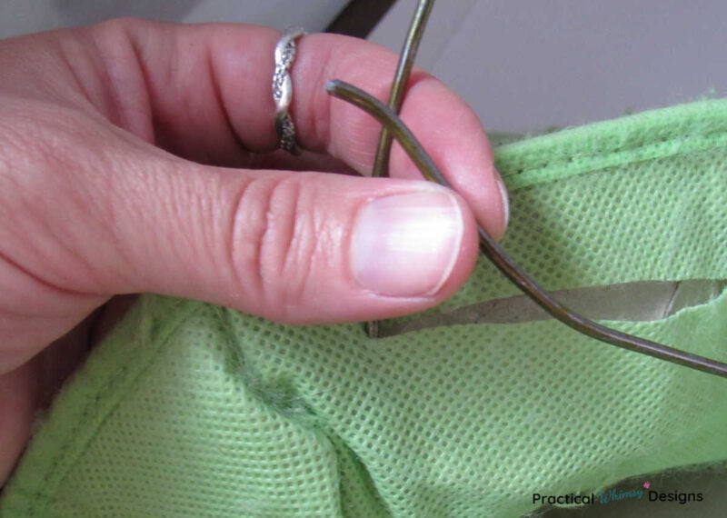 Stuffing one end of wire hanger frame into cloth box.