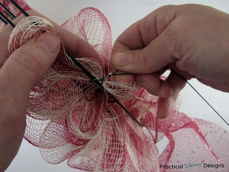 Attaching deco mesh ribbon to wire wreath frame with floral wire.