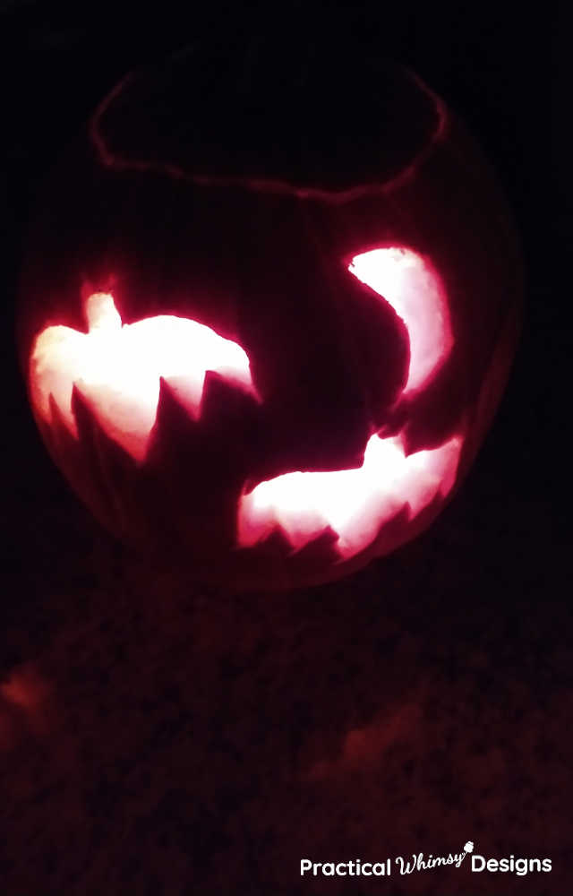 Glowing pumpkin with bats and moon carving