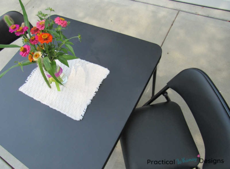 Refinished card table and chair with flowers on it.