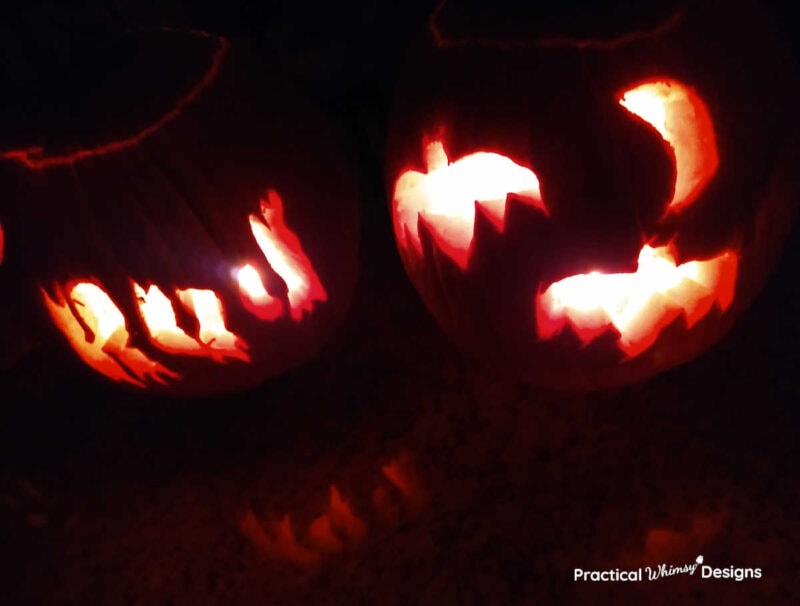 Bat and boo pumpkin stencils carved onto pumpkins and lit with tea lights