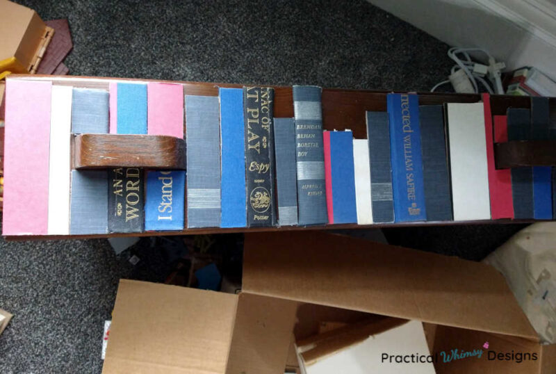 Faux books lined up on dresser drawer.