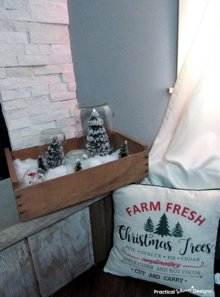Bottle brush trees in antique crate on hearth for old fashioned christmas decorating.