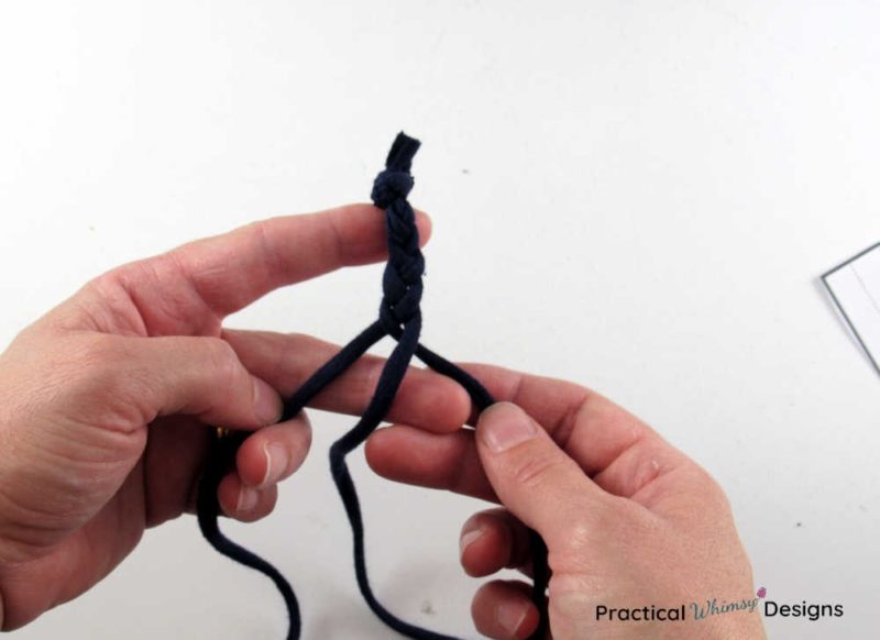 Hands braiding t-shirt fabric into diy ear saver