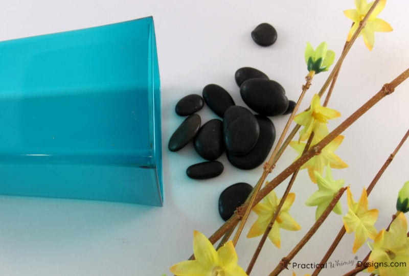 Vase, rocks, and flowers on ground