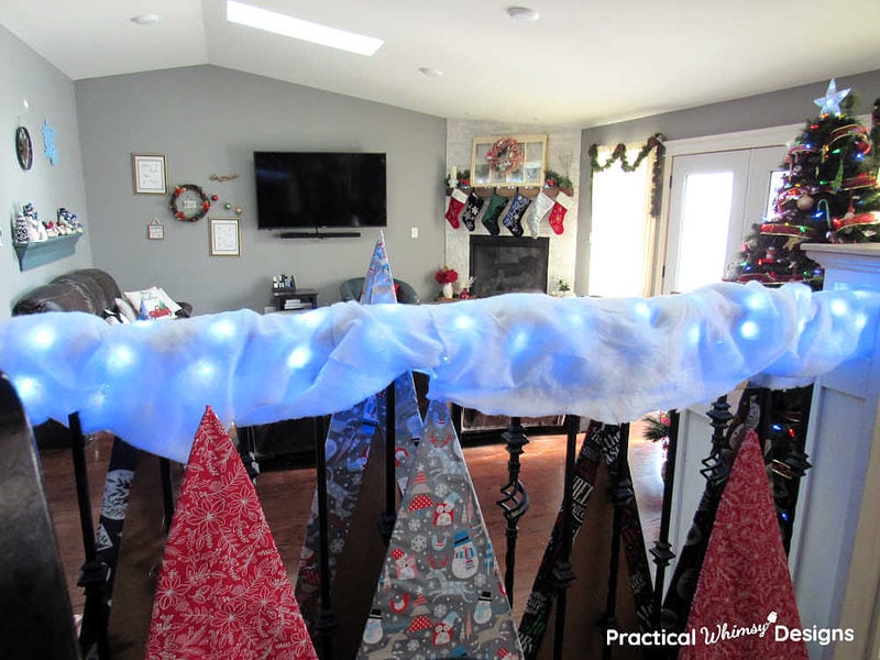 Christmas trees, blue snow on railings, and a family room decorated for Christmas.