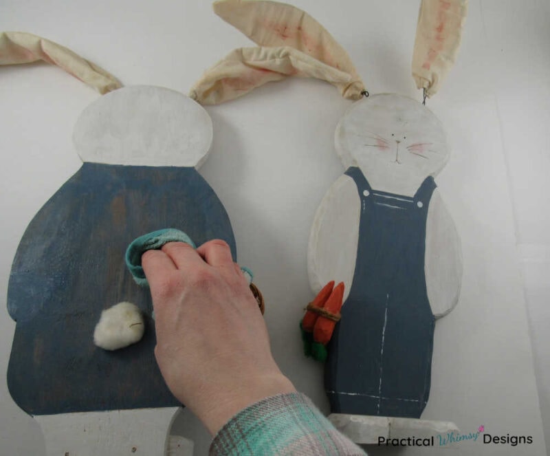 Cleaning painted wooden bunny decor with rag