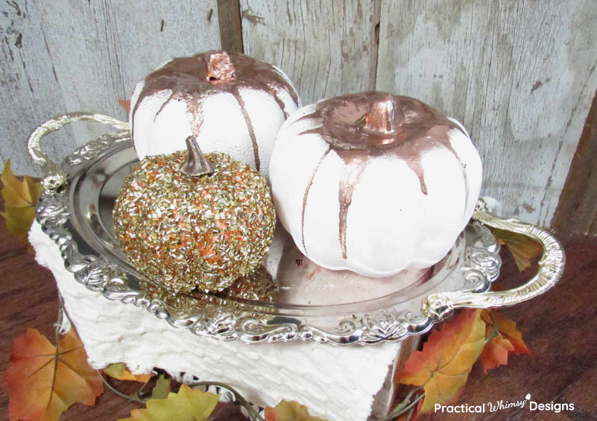 DIY Copper Dripped Pumpkins with gold pumpkin sitting on silver tray with fall leaves