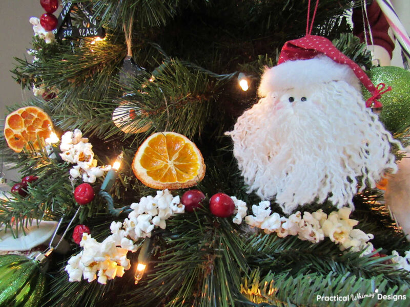 Cranberry and popcorn garland and ornaments on Christmas tree.