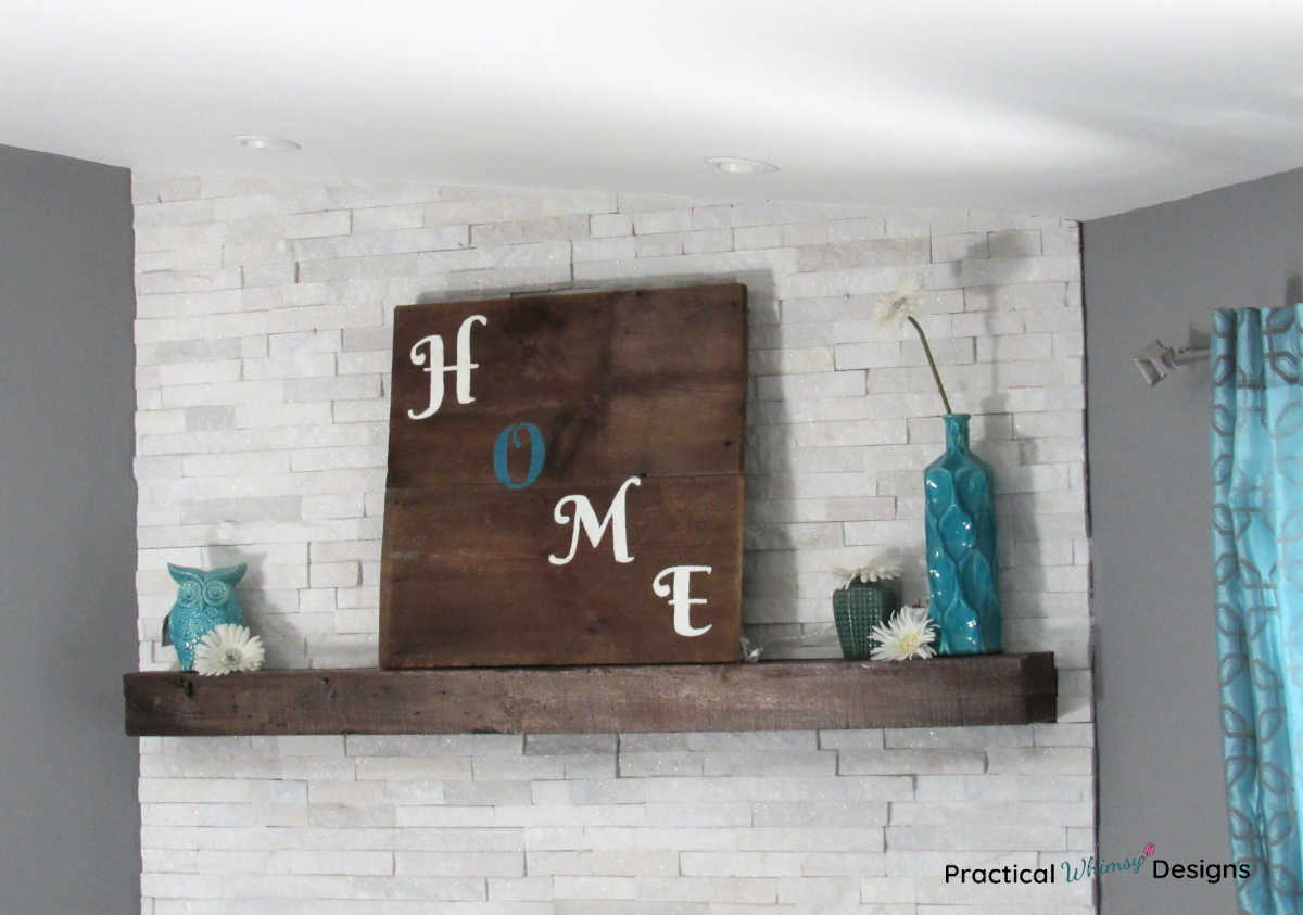 Wooden Home Sign on mantel with teal vases and white flowers