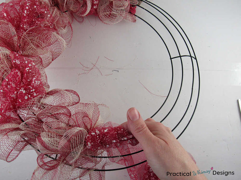 Tan and red DIY deco mesh wreath half completed.
