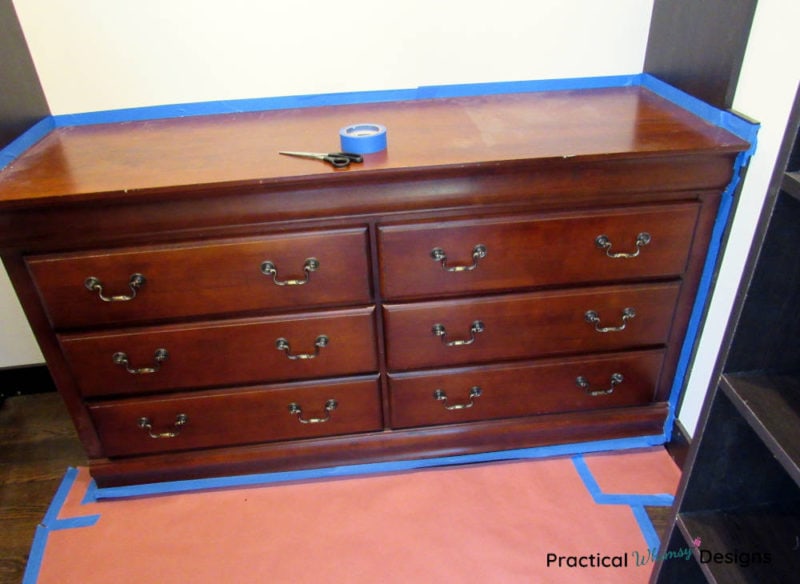 Cherry red dresser with painters tape on it