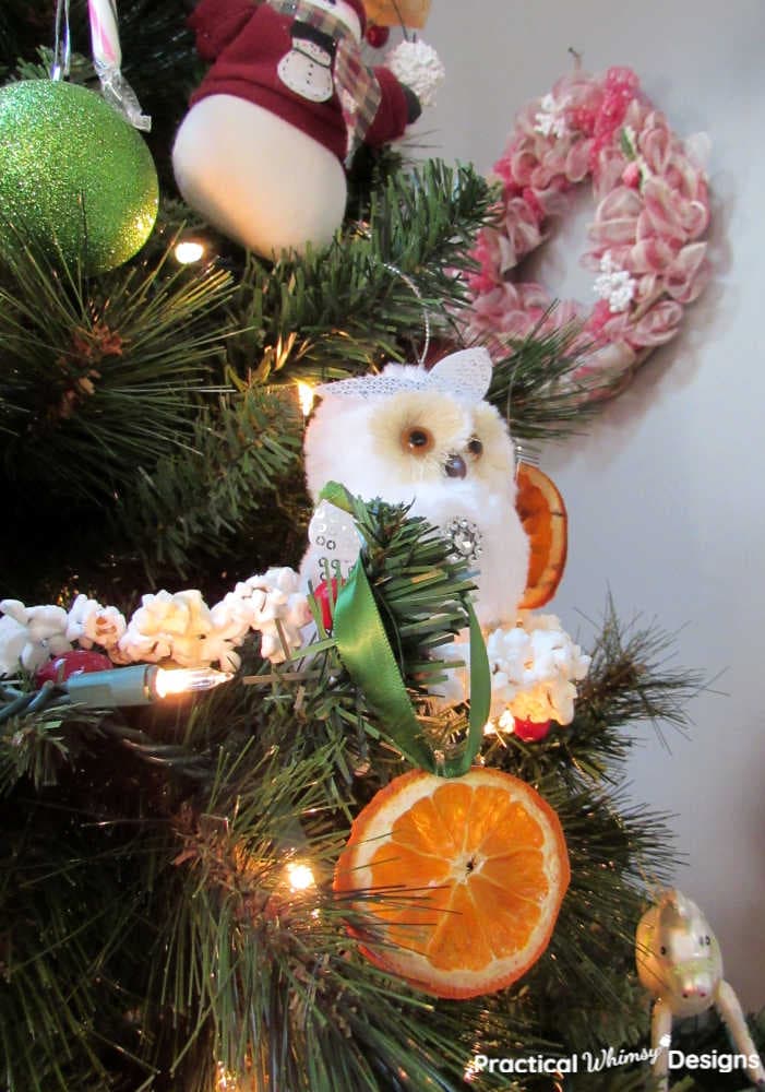 Dried orange and ornaments hanging on Christmas tree.