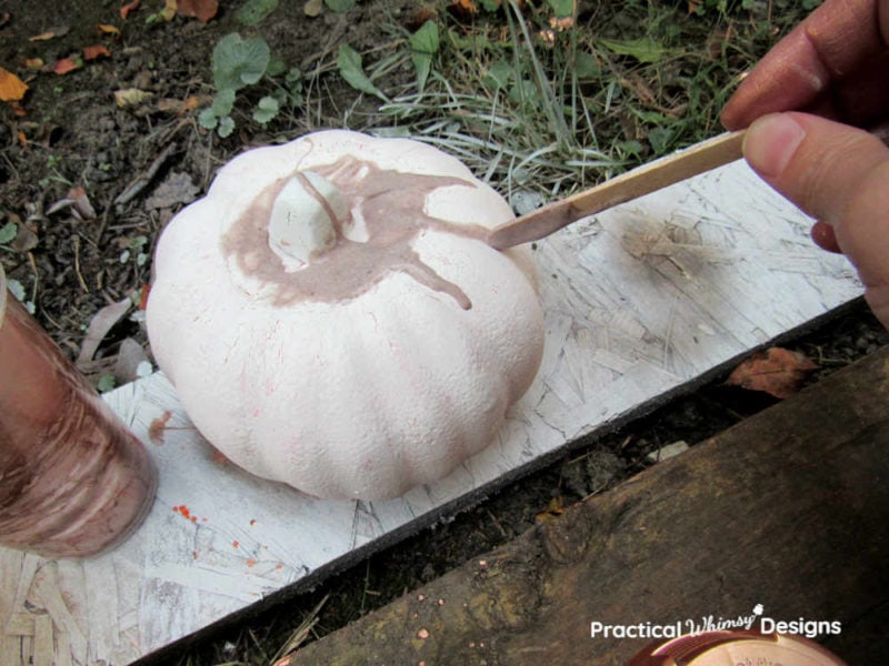 Dripping glue and paint mixture onto top of foam pumpkin.