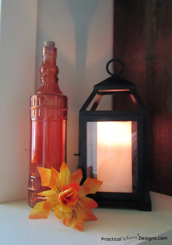 Fabric Flower made from fall leaves next to candle and bottle