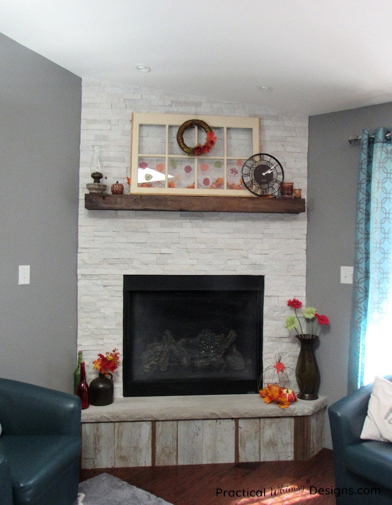Fireplace mantel and hearth decorated for fall.