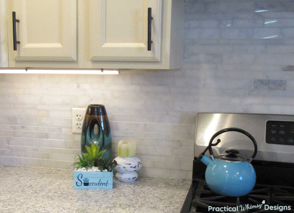 Farmhouse decorations and blue teapot in kitchen.