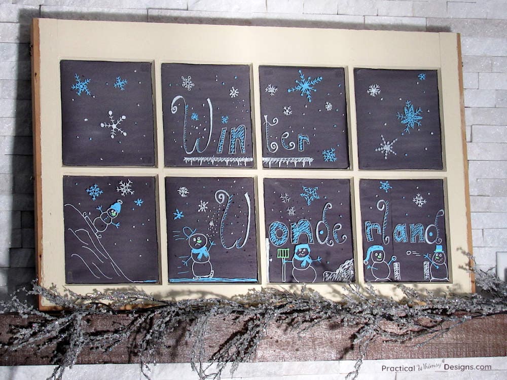 Window with winter themed chalk marker art on mantel.