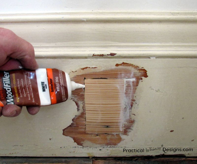 Filling gaps around trim patch with wood filler.