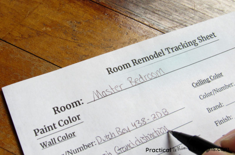 Filling out Room Remodel Tracking Sheet with a pen