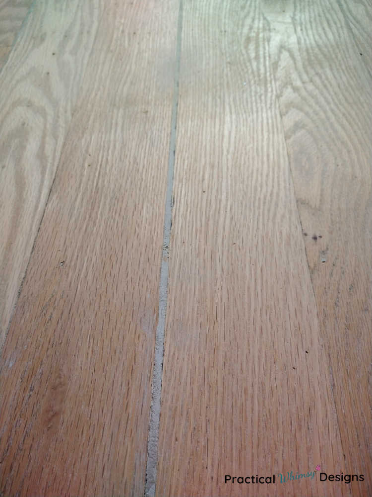 Floor with wood putty in cracks, sanded and ready for stain.