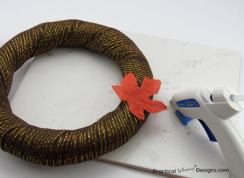 Gluing leaf on wreath.