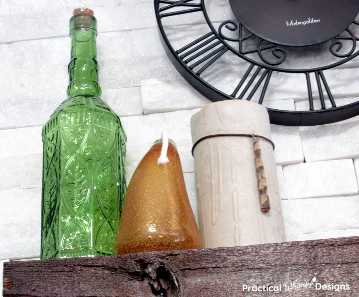 Green vase, orange lantern, and candle as part of a neutral fall decor idea for the home