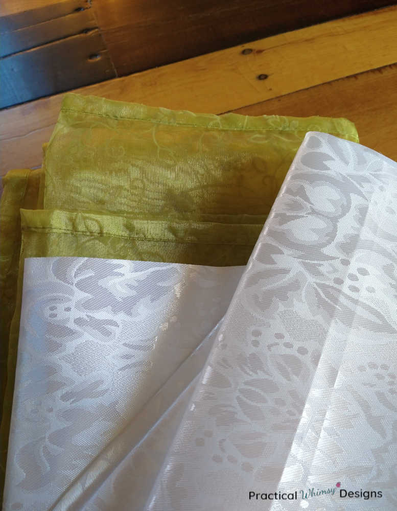 Green tablecloth and white table runner folded.