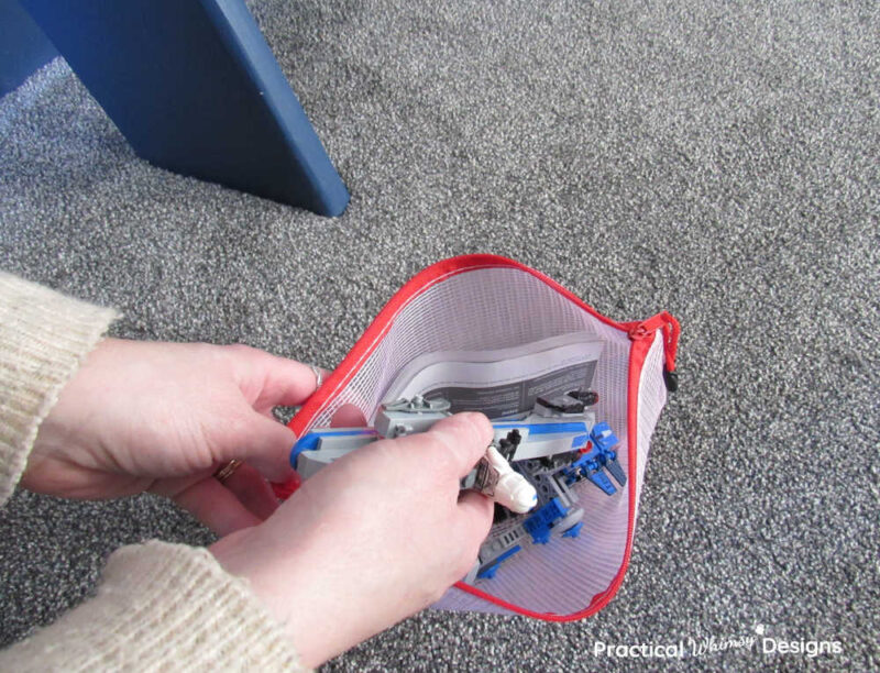 Hands organizing Lego sets in a storage bag