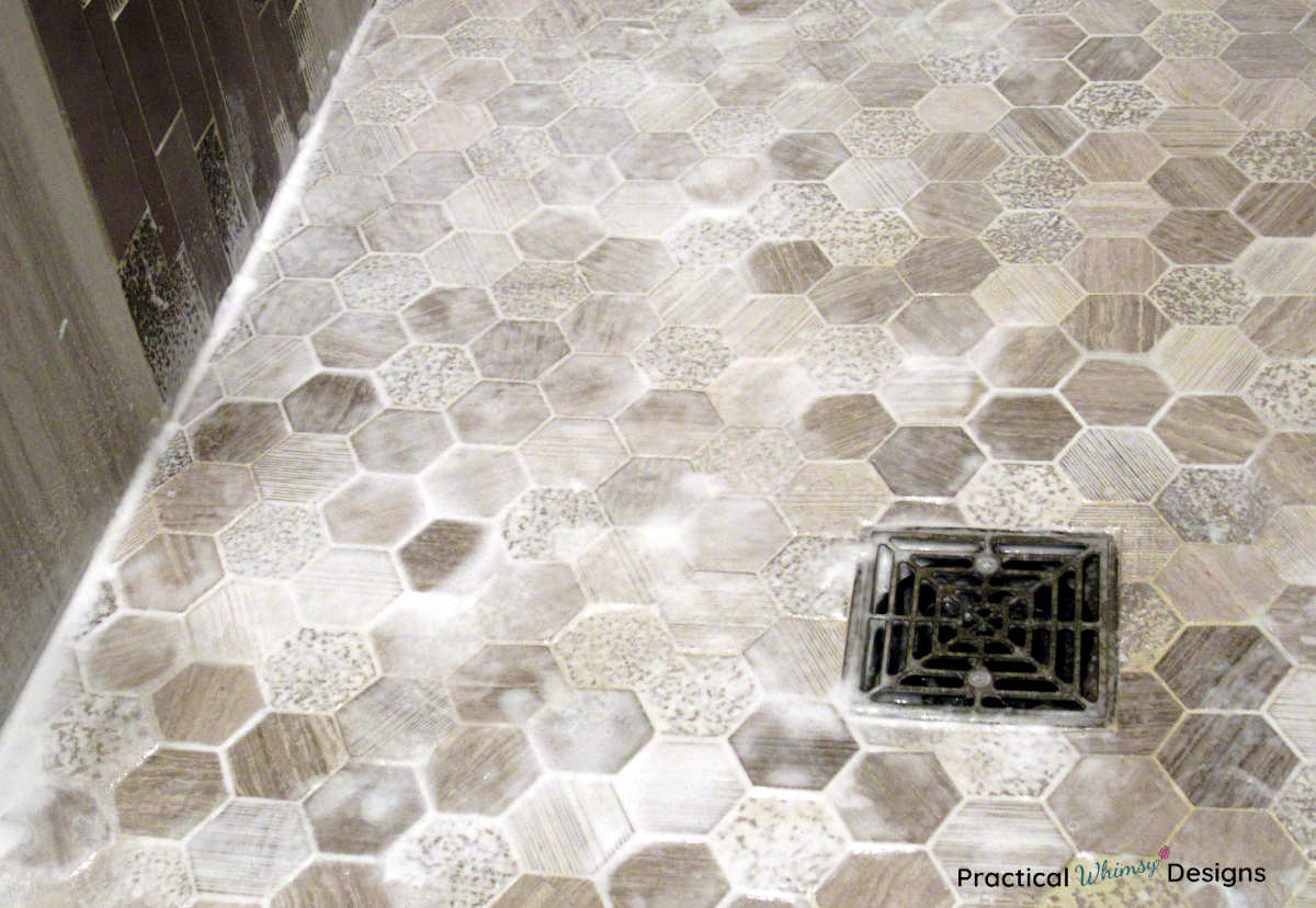 How to clean shower grout: picture of tile floor with cleaner on it.