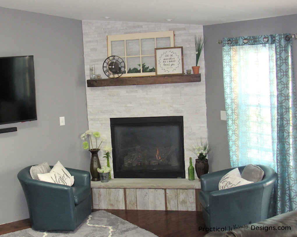 White stacked stone fireplace with rustic mantel