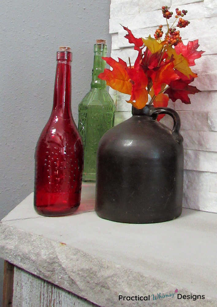 Brown jug with fall leaves on hearth