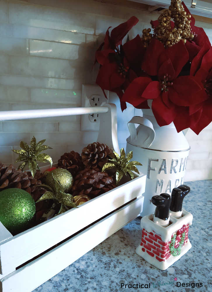 Pinecones and Christmas flowers in wooden caddy and jug 