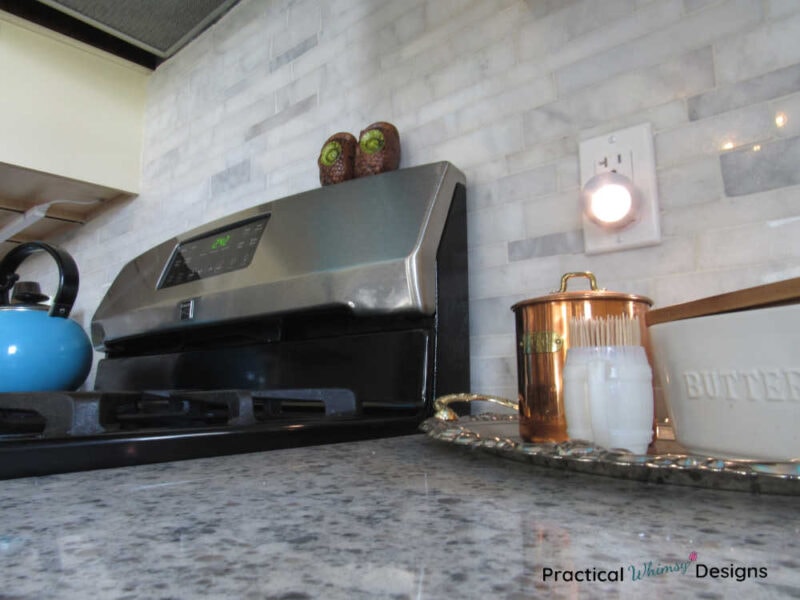 Gas stove with owl salt and pepper shakers with white marbled backsplash